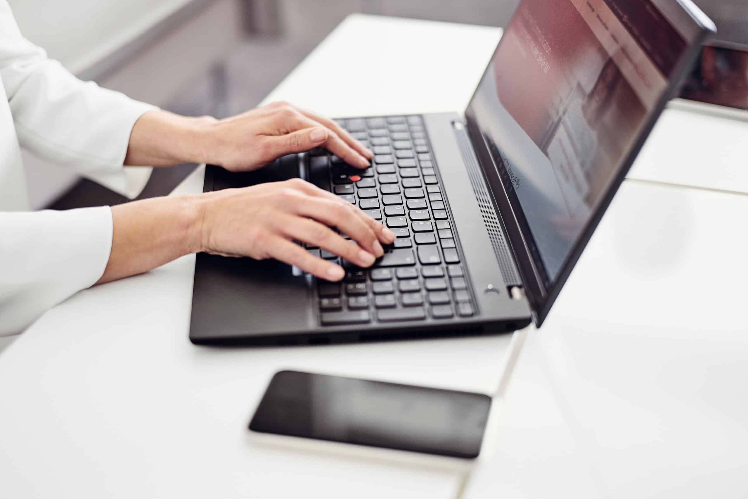 Člověk sedí u notebooku a prohlíží si webové stránky společnosti kwsoft®.